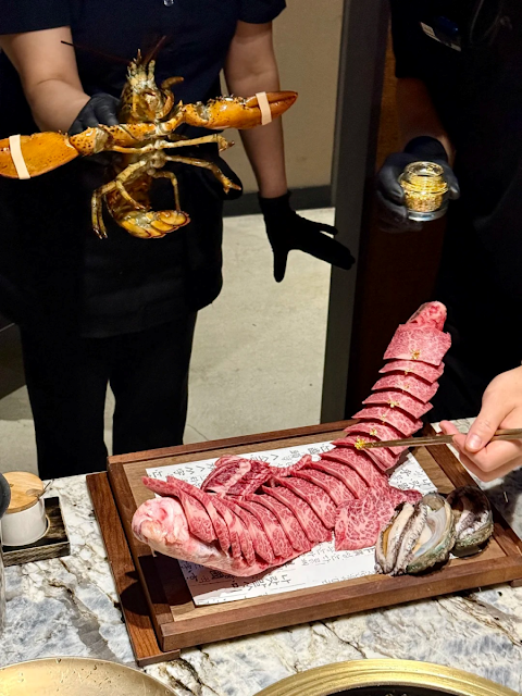 직원이 거대한 랍스터와 금가루 뿌려진 한우 갈비, 전복을 손질하고 있는 모습}